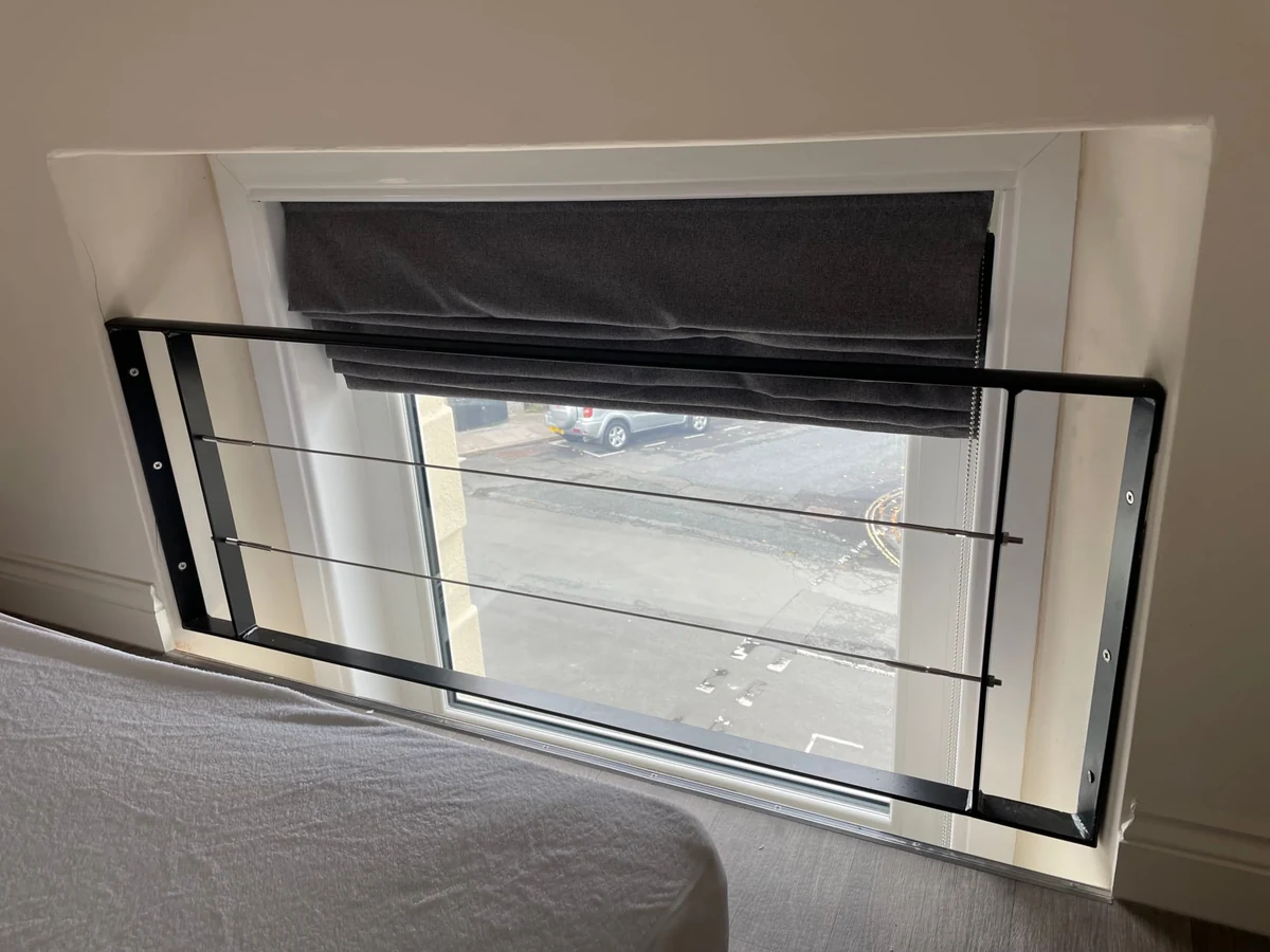 Metal safety guard fitted to an upper-floor window